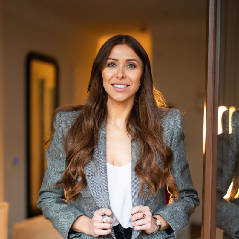 Profesjonalny portret biznesowy kobiety z dołu – uśmiechnięta kobieta w eleganckiej marynarce w kratę, fotografia biznesowa Warszawa